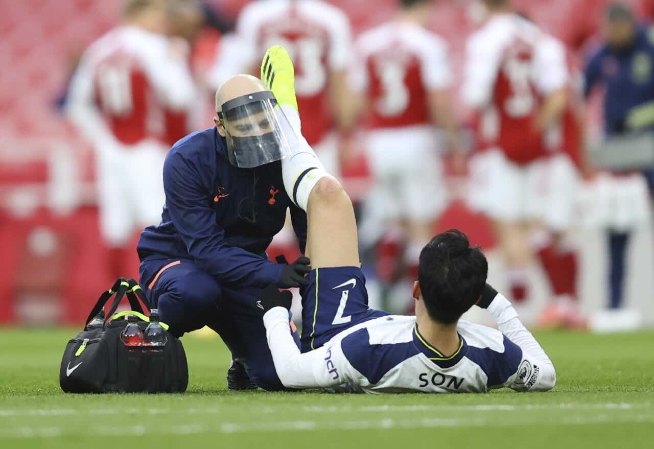 Tottenham Hotspur's Son Heung-min receives treatment for a hamstring injury during a Premier League match, sidelined for the upcoming Newcastle United clash.