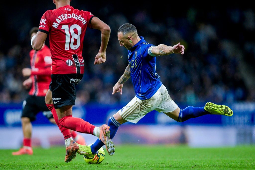 Real Oviedo player challenges Celta Vigo player during La Liga match