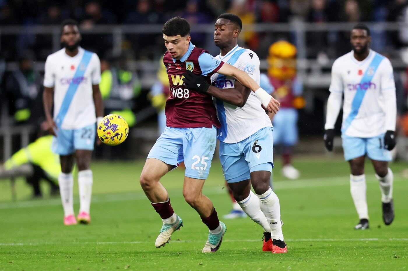 Burnley and Crystal Palace players challenging for the ball during a Premier League match at Turf Moor