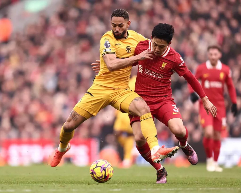 Liverpool and Wolves players compete for possession during Premier League match at Anfield