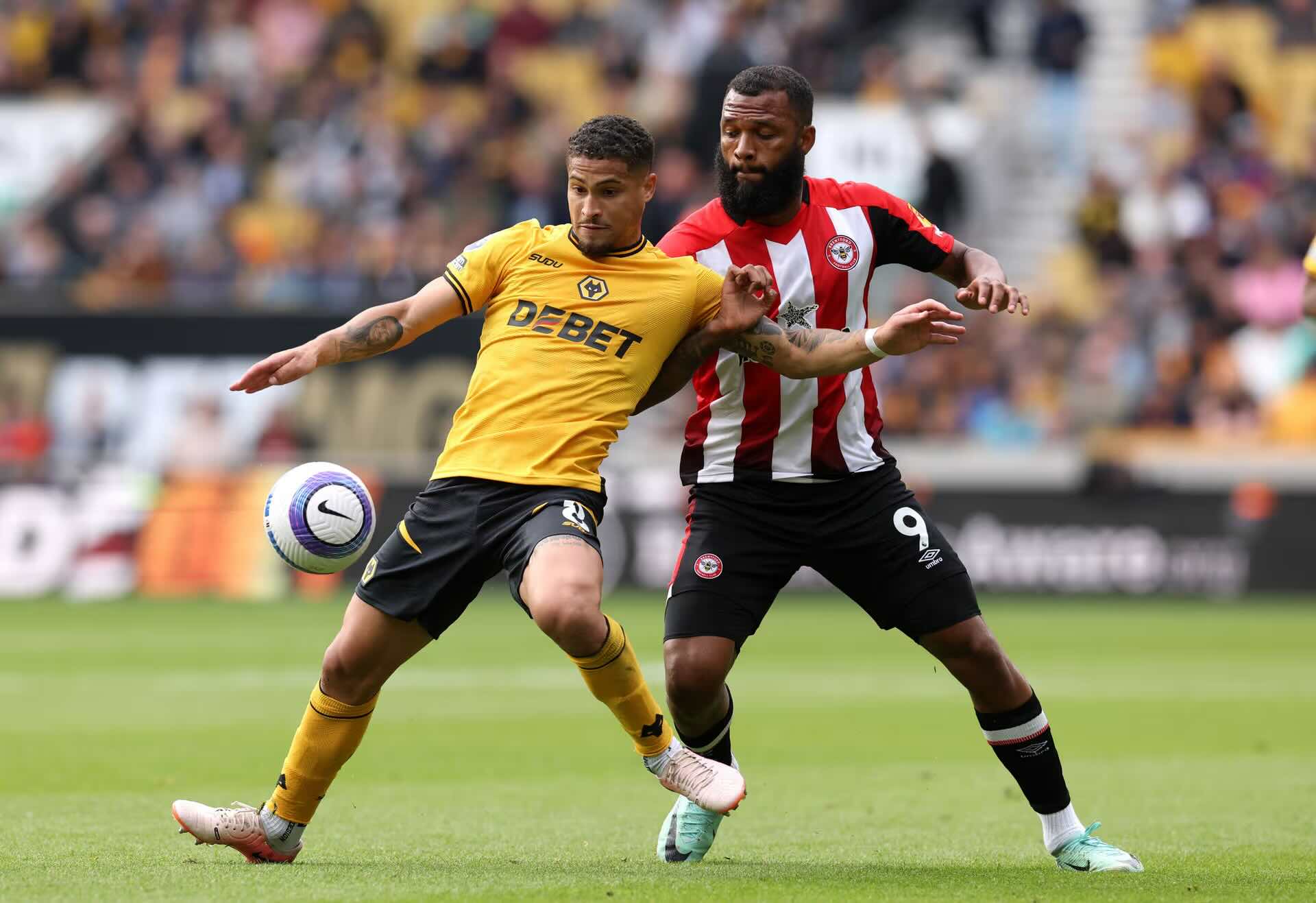 Wolves player challenged by a Brentford opponent during a Premier League match, showing the physical duels expected in Wolves vs Brentford.